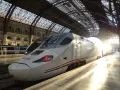Biały pociąg Renfe, najszybszy pociąg w Europie, stoi na dworcu pod szklanym dachem, oświetlony promieniami słońca.