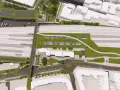 Nowoczesny, zintegrowany węzeł przesiadkowy z zielonymi dachami, torami kolejowymi, budynkami i drogami.