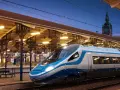 Nowoczesny wagon sypialny Pendolino na peronie dworca Gdańsk Główny. Wieczorne światła tworzą magiczną atmosferę.