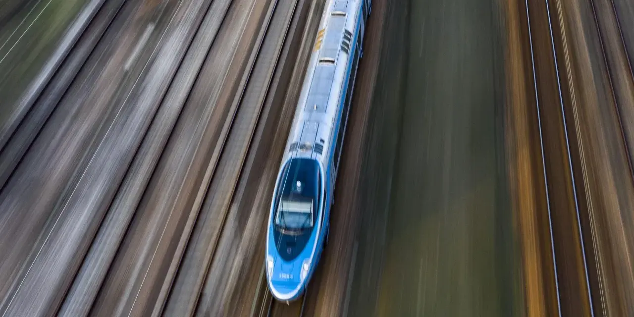 Pendolino pędzi po torach z Warszawy do Szczecina, tworząc na zdjęciu efekt rozmycia.