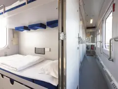 Wnętrze wagonu sypialnego PKP z białymi pościelami i niebieskimi zagłówkami. Korytarz z drzwiami i oknami.