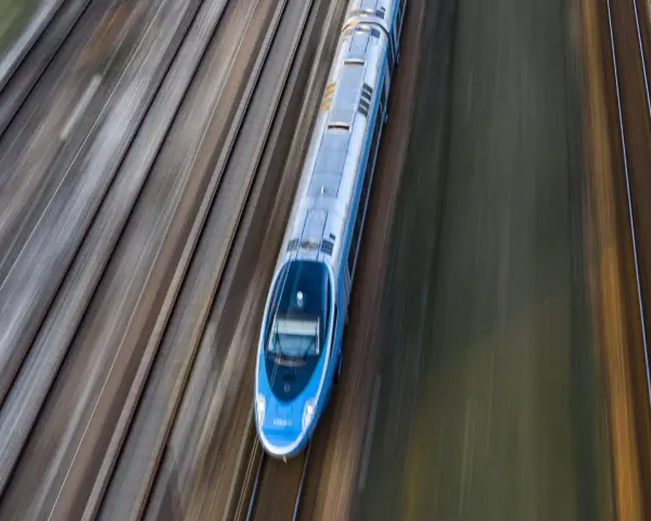 Pendolino pędzi po torach z Warszawy do Szczecina, tworząc na zdjęciu efekt rozmycia.