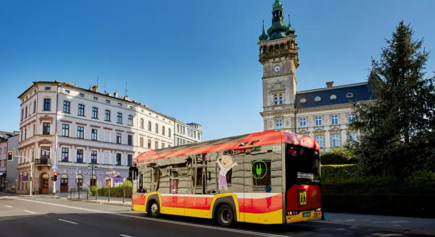 Autobus MPK Bielsko Biała z wizerunkiem uśmiechniętej postaci i zieloną wtyczką. Sprawdź rozkład jazdy MPK Bielsko Biała!