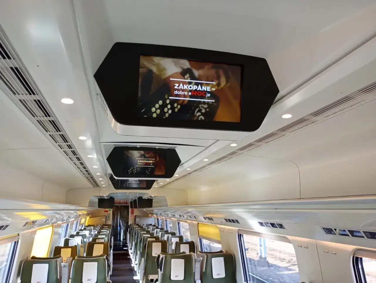 Wnętrze Pendolino Warszawa-Zakopane. Na ekranach wyświetla się reklama 