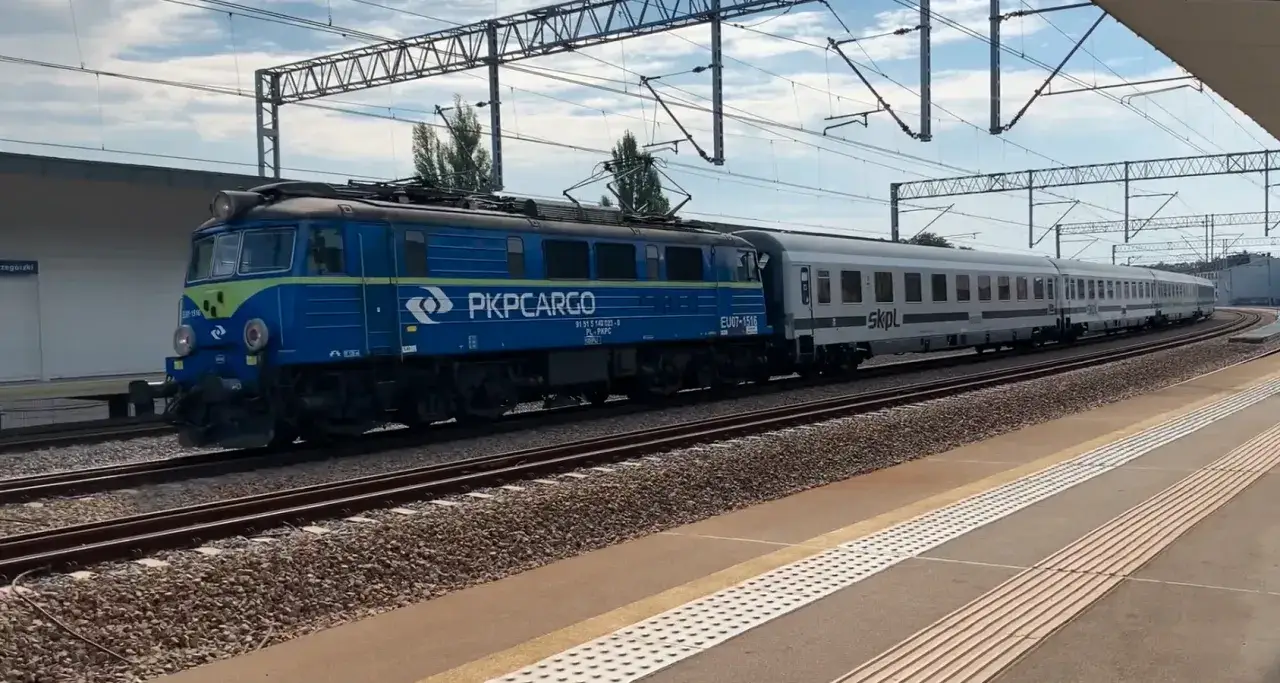 Niebieska lokomotywa PKP Cargo i białe wagony SKPL na torach. Stowarzyszenie kolejowych przewozów lokalnych w akcji.