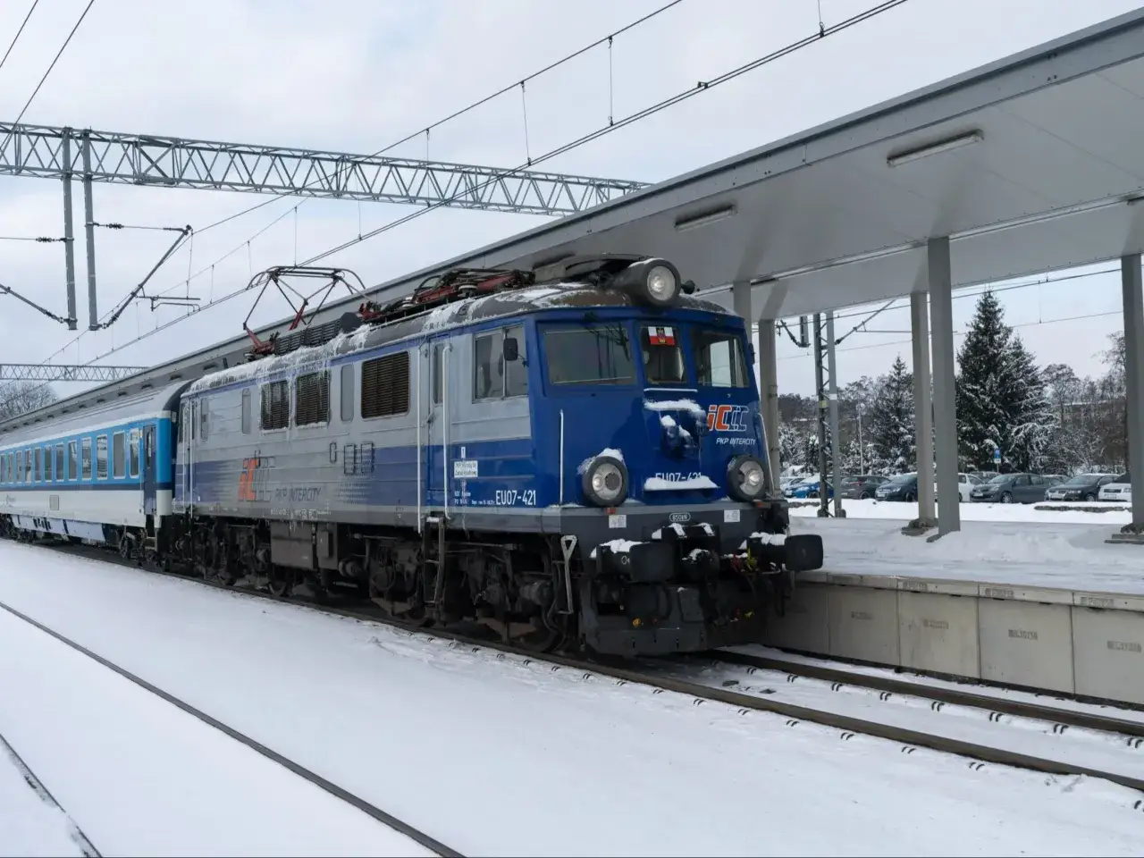 Zimowy dzień na dworcu. Pociągi PKP Intercity, które mogą zabrać Cię z Krakowa do Lublina, stoją na zaśnieżonych torach.