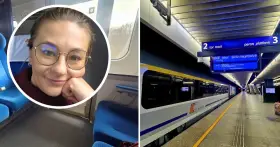 Uśmiechnięta kobieta w okularach w pociągu, obok peron z tablicą informującą o odjeździe pociągu **Berlin Warszawa Express**.