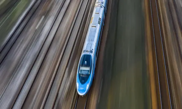 Pendolino pędzi po torach z Warszawy do Szczecina, tworząc na zdjęciu efekt rozmycia.
