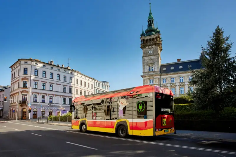 Autobus MPK Bielsko Biała z wizerunkiem uśmiechniętej postaci i zieloną wtyczką. Sprawdź rozkład jazdy MPK Bielsko Biała!